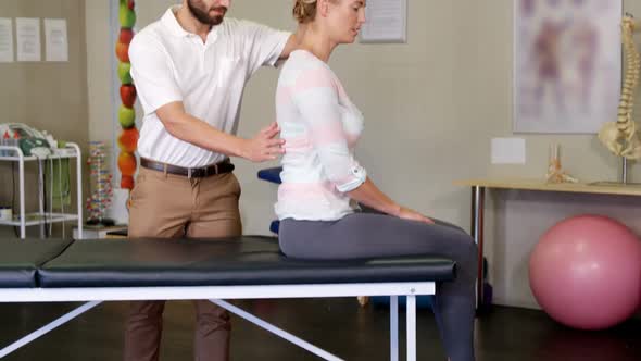 Male physiotherapist giving back massage to female patient