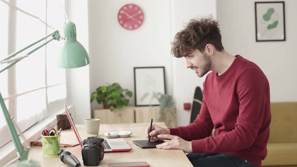 Hipster Young Graphic Designer Sketching on Tablet Working From Home Office