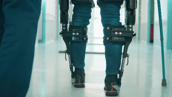 A Person is Training to Walk in the Exoskeleton with Assistance