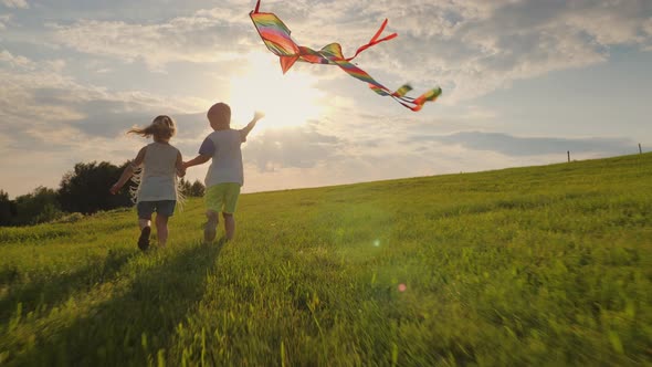 Little Children Playing with a Kite in the Meadow