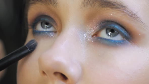 Makeup Artist Is Correcting Makeup Under the Eyes on Woman's Face Eyes Closeup