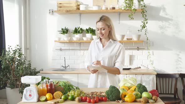 Woman Stands at a Table with a Lot of Vegan Food Ingredients She Talks About Proper Nutrition at