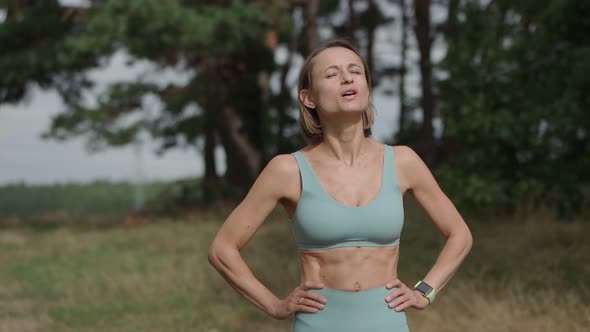 Medium Parallax Shot of Blond Caucasian Woman Jogger in Forest in Sunny Day