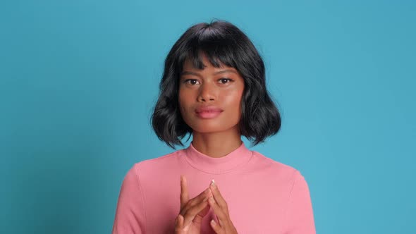 Mysterious Sly Woman Steeples Fingers and Schemes Something Tries Over Blue Wall