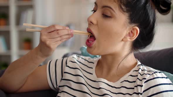 Tracking video of woman eating chopsticks Chinese food