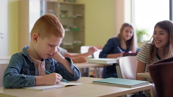 Video of sad boy sitting mocked in class. Shot with RED helium camera in 8K.