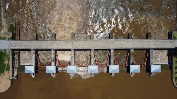 Aerial view of the water released from the concrete dam's drainage channel as the overflow