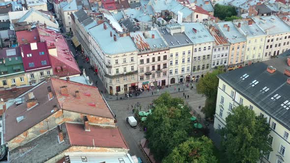 Aerial view of people walking the streets of Lviv Ukraine during sunset in the summer of 2021 surrou