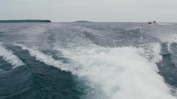 The water parts and blows. High speed footage of dramatic boat wakes splashing behind a boat in Tobe