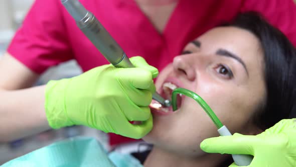 Dentist Cleans Woman's Teeth with Professional Toothpaste and Automatic Brush