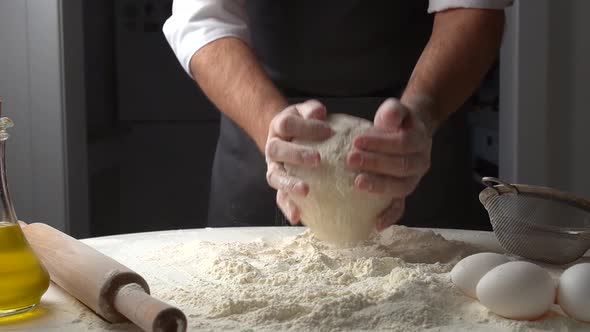 Chef Sprinkles Piece of Baking Dough with Flour