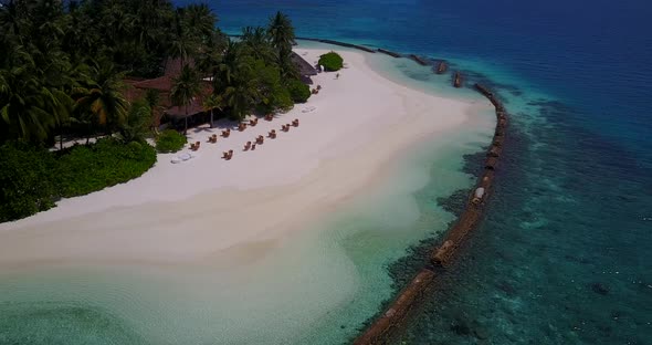 Wide angle birds eye travel shot of a paradise sunny white sand beach and blue water background 