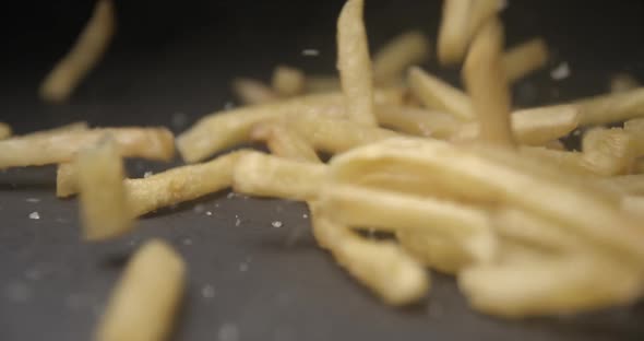 French fries with salt close up slow motion studio, tasty fast food