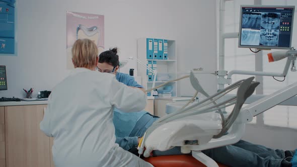 Woman Dentist Using Instrument to Do Drill Procedure