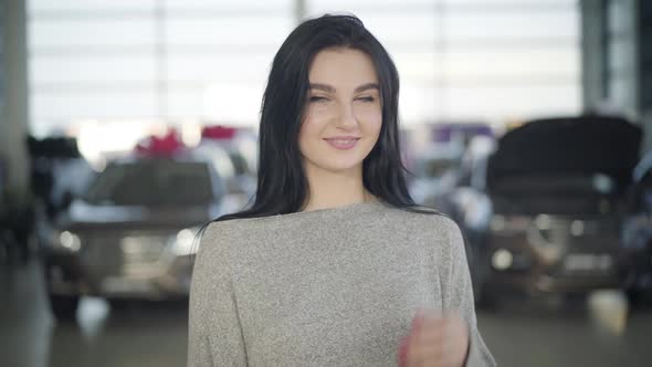 Portrait of Charming Young Caucasian Woman with Black Hair and Green Eyes Looking at Camera and