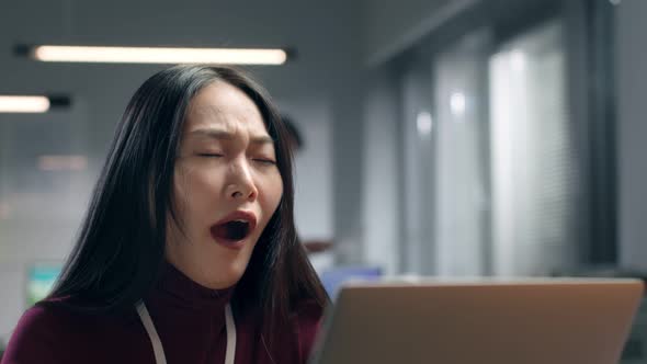 Exhausted Asian Businesswoman Yawn Working Late in Office