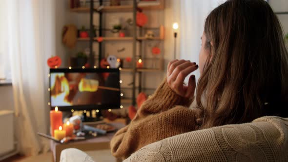 Young Woman Watching Tv at Home on Halloween