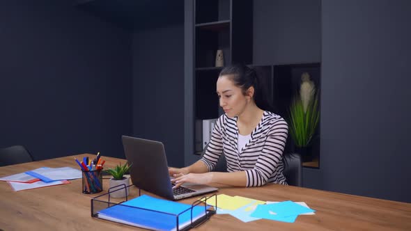 Employee in Startup Company Smiling Using Laptop