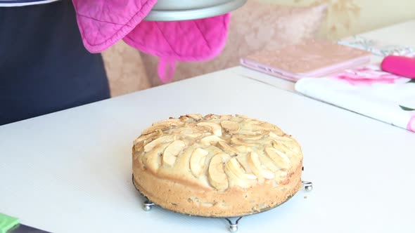 A Woman Takes Out A Baked Apple Pie From A Metal Mold. Cooking Charlotte At Home.