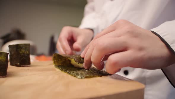 Hands of Japanese Chef Preparing Gunkan Nigiri Closeup