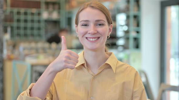 Portrait of Thumbs Up By Positive Young Woman 