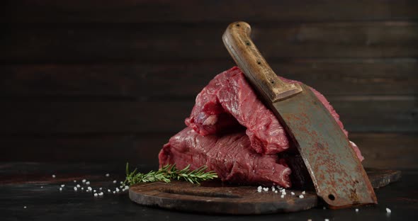 Beef Raw with a Large Knife Slowly Rotates on the Table.