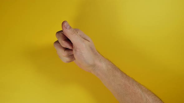 Male Hand Doing A positive Thumbs Up on yellow screen background