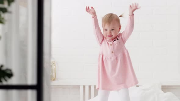 Happy Child Girl Having Fun Jumping and Playing Funny Active Game in Parents Bed Bouncing Fooling