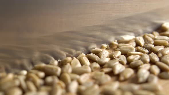 Chopping sunflower seeds with a knife on a wooden cutting board