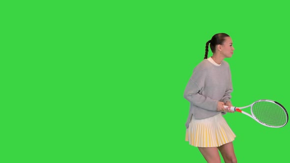 Girl with Tennis Racket Imitating the Game on a Green Screen Chroma Key