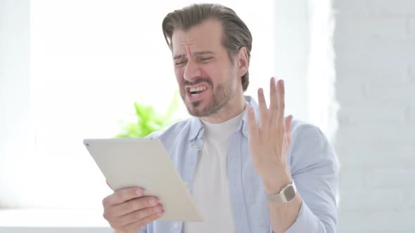 Young Man Having Loss on Tablet in Office