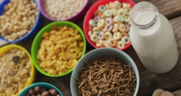 Video of cereals in colorful bowls on wooden kitchen worktop