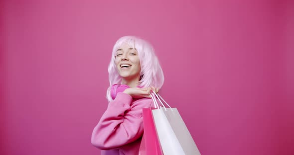 Happy Girl Enjoys After Shopping with Colorful Bags in Pink Colour Concept