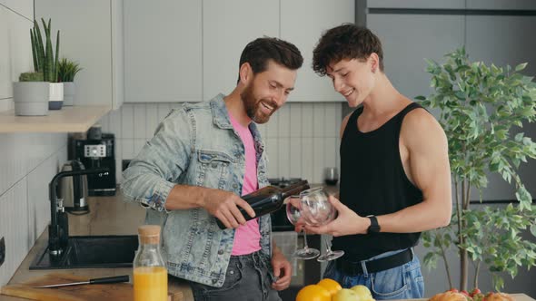 Gays Couple in Love Having Fun Drinking Wine Talking Preparing Meal in Kitchen at Home