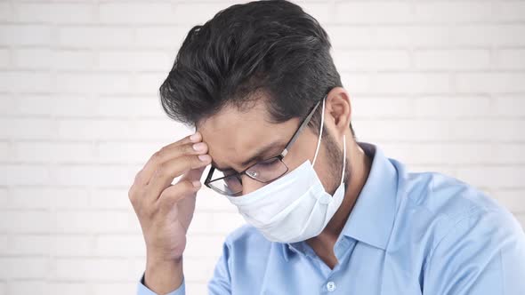 A Young Asian Man with Protective Mask in Face Feeling Sad