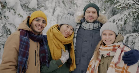 Portrait of Young People Diverse Group Standing in Winter Forest Smiling Looking at Camera