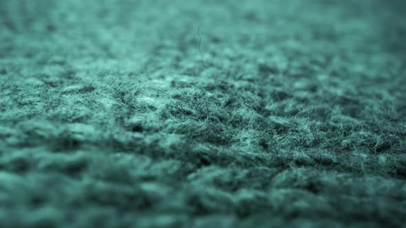 Extreme detail view of sheep wool cloth texture flowing in macro dolly shot.