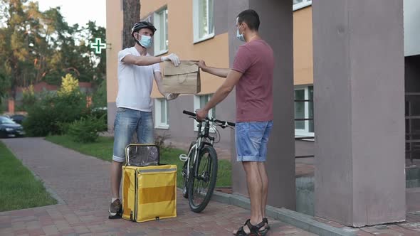 Food delivery service during the quarantine period on a bicycle in a yellow thermo backpack.