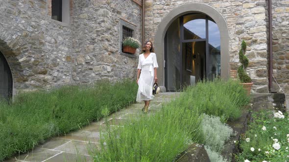 A woman walking on stone path while traveling at a luxury resort in Italy, Europe.