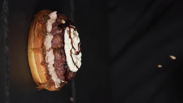 Sunflower seeds falling on an egg burger in slow motion. Vertical slow motion shot.