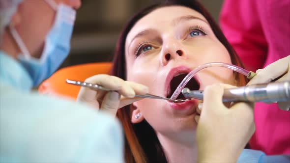 A Dental Clinic Doctor Flushes the Patient's Teeth with Water and a Mirror