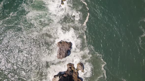 Aerial top down view reveal shot capturing Saint Michael the Archangel fort and Nazare lighthouse.