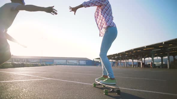 Young Attractive Mixed Race Couple Riding Skateboards and Having Fun Slow Motion