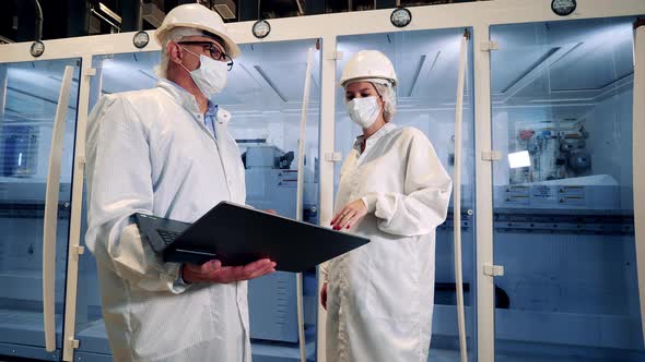 Two Engineers in Lab Coats are Discussing Modern Technologies