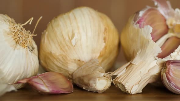 Close up of garlic bulbs on rustic table. Pan shot.