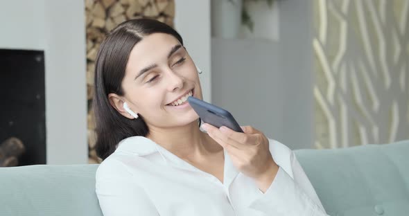 Young Smiling Woman Recording Audio Message to Friend