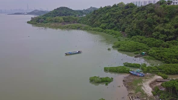 A dynamic birdseye aerial footage of the peaceful Lau Fau San Island with fishing boats voyaging the