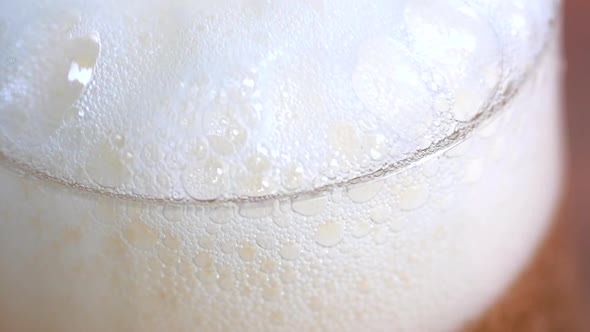 Detailed super slow motion footage of a beer. glass being filled up with lager beer. Foam builds up