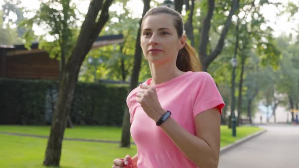 Woman in Pink Tshirt Jogging in Park