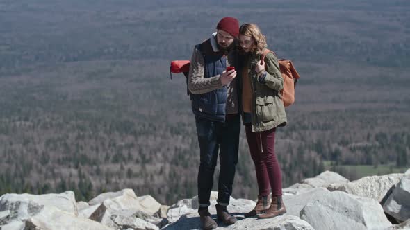 Couple Checking Direction on Phone during Hiking Trip